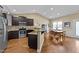 An open kitchen features dark cabinets, granite countertops, stainless steel appliances, and hardwood floors at 420 Carsons Creek Trl, Wendell, NC 27591