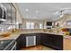 Kitchen features granite countertops, dark cabinets, stainless steel appliances, and open access to the living room at 420 Carsons Creek Trl, Wendell, NC 27591