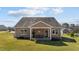 The home's rear exterior features a covered porch, well-maintained lawn, and tidy landscaping, enhancing its curb appeal at 420 Carsons Creek Trl, Wendell, NC 27591