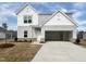 Charming two-story home with light gray siding, an attached garage, and a well-manicured lawn on a sunny day at 44 Rolling Banks Dr, Louisburg, NC 27549