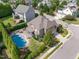 Aerial view of a luxurious home with a kidney-shaped pool, patio, and manicured landscaping in a residential neighborhood at 5026 Clyden Cv, Raleigh, NC 27612