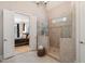 Walk-in shower with tiled walls and glass surround, adjoining a spacious bedroom creating a luxurious retreat at 5026 Clyden Cv, Raleigh, NC 27612
