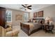 Comfortable bedroom with a wooden bed frame, ceiling fan, neutral colors and plenty of natural light at 5026 Clyden Cv, Raleigh, NC 27612
