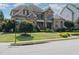 A well-maintained lawn and lush shrubs accent this stone and brick home near a street corner at 5026 Clyden Cv, Raleigh, NC 27612