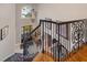 Elegant foyer with a dark wood front door, iron staircase, chandelier, and art-adorned walls, creating a striking entrance at 5026 Clyden Cv, Raleigh, NC 27612