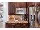 Kitchen detail showcases granite counters, stainless appliances, and dark wood cabinetry with a decorative tile backsplash at 5026 Clyden Cv, Raleigh, NC 27612