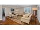 An elegant living room featuring hardwood floors, a patterned rug, and comfortable, neutral furniture at 5026 Clyden Cv, Raleigh, NC 27612