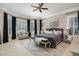 Serene main bedroom with a sitting area, plush bedding, a ceiling fan, and natural light from the windows at 5026 Clyden Cv, Raleigh, NC 27612