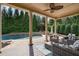 Inviting covered patio with ample seating, columns, a ceiling fan, and a view of the pool at 5026 Clyden Cv, Raleigh, NC 27612