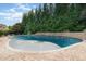 In-ground pool with unique shape, lush landscaping, and a well-maintained patio area at 5026 Clyden Cv, Raleigh, NC 27612