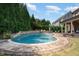 A beautiful in-ground pool surrounded by a lush green yard, mature trees and patio at 5026 Clyden Cv, Raleigh, NC 27612