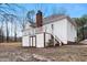 Exterior view of a white house with a backyard, deck and a brick chimney at 715 Thompson Rd, Garner, NC 27529