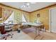 Craft room featuring two sewing tables and natural light from multiple windows, for hobbies and projects at 721 Thompson Rd, Garner, NC 27529