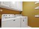 Laundry area with white cabinets, shelving and modern washer and dryer, for a functional space at 721 Thompson Rd, Garner, NC 27529