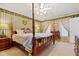 Inviting main bedroom featuring a four-poster bed, decorative wallpaper, and soft lighting at 721 Thompson Rd, Garner, NC 27529