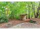 Backyard featuring a fire pit and a storage shed surrounded by lush greenery at 725 Littleleaf Ct, Holly Springs, NC 27540