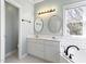 Bright bathroom with double vanity, stylish mirrors, and tub with white subway tile at 725 Littleleaf Ct, Holly Springs, NC 27540