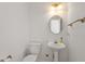 Bright half bathroom features pedestal sink, toilet, and decorative mirror at 725 Littleleaf Ct, Holly Springs, NC 27540