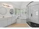Bright bathroom featuring tub, shower, double sinks and vanity at 725 Littleleaf Ct, Holly Springs, NC 27540