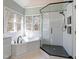 Modern bathroom with a soaking tub, separate glass shower, and stylish black fixtures at 725 Littleleaf Ct, Holly Springs, NC 27540
