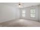 Bedroom features carpeted floor, two windows, and ceiling fan at 725 Littleleaf Ct, Holly Springs, NC 27540