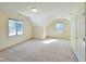 Large bonus room with neutral carpet, lots of natural light, and angled ceilings at 725 Littleleaf Ct, Holly Springs, NC 27540