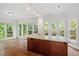 Bright breakfast nook features hardwood floors, a granite island, and access to the deck via French doors at 725 Littleleaf Ct, Holly Springs, NC 27540