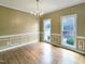 Bright dining room featuring hardwood floors, classic chandelier, and large windows at 725 Littleleaf Ct, Holly Springs, NC 27540
