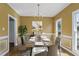Staged dining room featuring a modern chandelier, wall art, and a table set for a meal at 725 Littleleaf Ct, Holly Springs, NC 27540