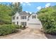 Inviting two-story home with a two-car garage and a well-maintained driveway, surrounded by lush greenery at 725 Littleleaf Ct, Holly Springs, NC 27540