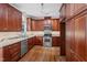 Modern kitchen equipped with stainless steel appliances, granite countertops, and ample storage space in wooden cabinets at 725 Littleleaf Ct, Holly Springs, NC 27540