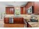Well-equipped kitchen featuring stainless steel appliances, granite countertops, and dark wood cabinetry at 725 Littleleaf Ct, Holly Springs, NC 27540