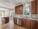 Eat-in kitchen boasts granite countertops, wood cabinets, and stainless steel dishwasher at 725 Littleleaf Ct, Holly Springs, NC 27540