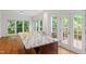 Bright breakfast nook with granite countertop island, hardwood floors, and doors leading to a deck at 725 Littleleaf Ct, Holly Springs, NC 27540