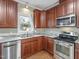 Updated kitchen boasts stainless steel appliances, granite countertops, and rich wood cabinetry at 725 Littleleaf Ct, Holly Springs, NC 27540