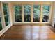 Bright living room features hardwood floors and large windows offering backyard views at 725 Littleleaf Ct, Holly Springs, NC 27540