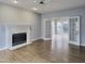 Bright living room with a fireplace, hardwood floors, and double doors leading to sunroom at 725 Littleleaf Ct, Holly Springs, NC 27540