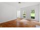 Living room features hardwood flooring, windows offering outside views, and neutral white walls at 725 Littleleaf Ct, Holly Springs, NC 27540