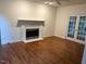 Cozy living room with fireplace, hardwood floors, and french doors to outdoor space at 725 Littleleaf Ct, Holly Springs, NC 27540