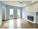 Spacious living room with a classic fireplace, hardwood floors, and natural light from the windows at 725 Littleleaf Ct, Holly Springs, NC 27540