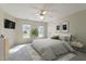 Staged main bedroom with a comfortable bed, stylish decor, and ample natural light from two windows at 725 Littleleaf Ct, Holly Springs, NC 27540