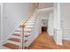 Elegant staircase with wooden steps and white railings, leading to the upper level of this beautiful home at 725 Littleleaf Ct, Holly Springs, NC 27540