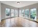 Bright sunroom with hardwood floors and multiple windows offering views of the landscaped yard at 725 Littleleaf Ct, Holly Springs, NC 27540