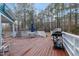 A large wooden deck offers ample space for outdoor dining and relaxation with a gas grill and wooded backdrop at 725 Thompson Rd, Garner, NC 27529