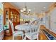 Elegant dining room with white chairs, chandelier, and hardwood floors near the kitchen at 725 Thompson Rd, Garner, NC 27529