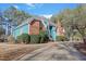 Charming two-story home with a brick chimney, blue siding, manicured landscaping, and a curved driveway at 725 Thompson Rd, Garner, NC 27529