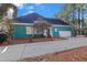 Charming home featuring a teal exterior, well-manicured landscaping, and an attached garage at 725 Thompson Rd, Garner, NC 27529