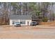 A two-car garage with attached carport sits in front of a dirt lot with cars in front at 725 Thompson Rd, Garner, NC 27529