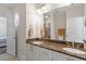 Well-lit bathroom features double sinks with granite countertops and decorative bronze fixtures at 7250 Hwy 751 # 2109, Durham, NC 27707