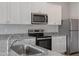 Kitchen features stainless steel appliances, white cabinetry, and gray granite countertops at 809 Rhino Bnd, Oxford, NC 27565
